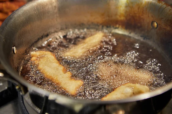 Bugnes, Fransız çörekleri tencerede kaynar yağ içinde.