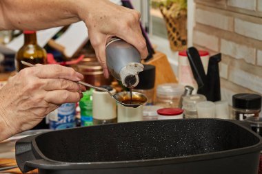 Şef taraça sosunu gaz sobasında dikdörtgen tavada kızartılmış sığır etine döküyor. Fransız gurme mutfağı.