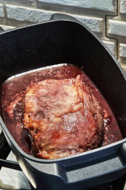 Bir parça et, şarap sosunda soğanla kızartılır. Gaz ocağında ateşin üzerinde dikdörtgen tavada..