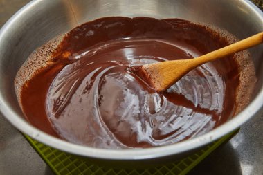 Şef armut ve fındıklı çikolatalı keki ahşap spatulayla karıştırıyor. Adım adım tarif.
