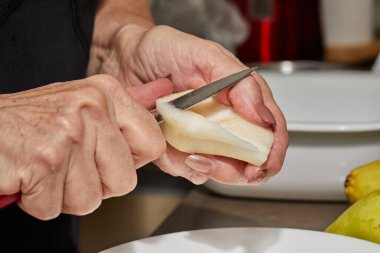 Şef armutları armut ve fındıklı çikolatalı pasta için dilimlere ayırır. Adım adım tarif.