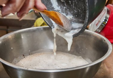 Şef armut ve fındıklı çikolatalı kek karışımına krema döker. Adım adım tarif.