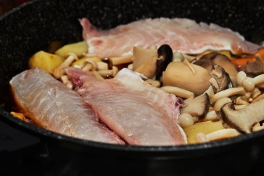 Havuç, mantar ve patatesle pişirilmiş balık, sebzeli palmiye balığı güveci yapmak için gaz sobasında tavada kızartılır. Adım adım tarif.