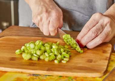Chef cuts the asparagus into small pieces to prepare the dish.