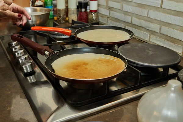 Chef pan-frying Crepe Suzette pancakes with cognac and citrus sauce.