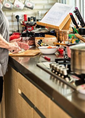 Chef cuts cheese in the home kitchen, for cooking according to a recipe from the Internet.