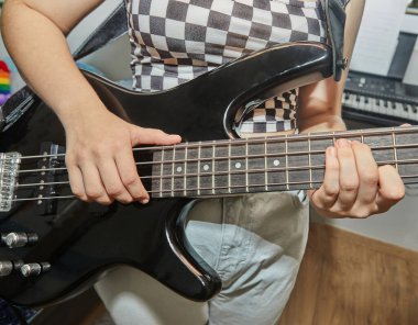 Ergen, ev müziği stüdyosunda bas gitar çalıyor..