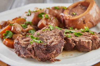 Sebzeli Ossobuco. Bıçak ve çatalla ahşap arka planda. Kapat.