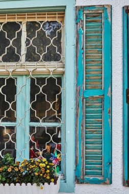 Ahşap pencereler ve kepenkler gün batımında maviye boyanmış..