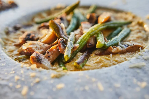 Polenta and mushrooms. Polenta cream in butter and cream, mushrooms and green beans sauteed with truffle cream and parmesan. Selective focus