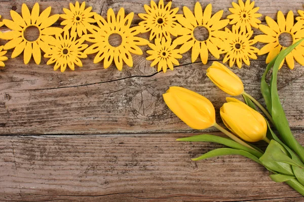 Žlutá květinovou výzdobu na dřevěné desce — Stock fotografie