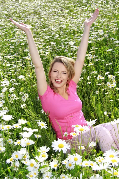 Glückliche Frau mit ausgebreiteten Armen im Blumenfeld — Stockfoto