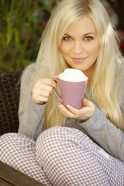 Bella donna bionda con tazza di latte macciato seduta — Foto Stock