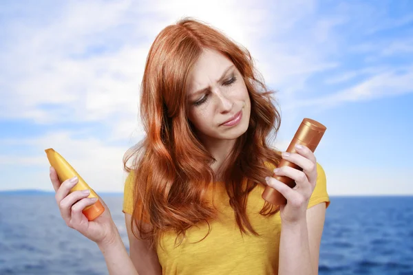 Femme aux cheveux rouges avec lotion solaire — Photo