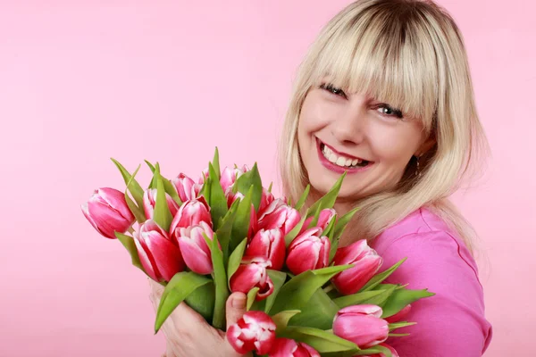 Heureuse femme souriante avec bouquet de fleurs de tulipe — Photo