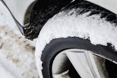 Snow stuck on car wheel on snowy day