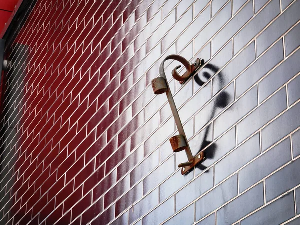 Cuore formato da portabandiera e il suo riflesso sulla parete di mattoni rosso scuro — Foto Stock