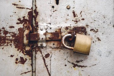 Paslı kapı kapağında asma kilit yatay asılı.