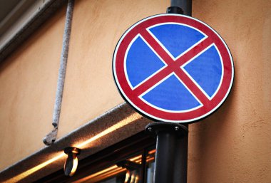 Kahverengi beton bina köşesinde duran yuvarlak tabela yok.