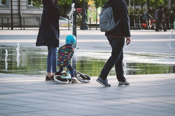 Kisgyerek Kis Kerékpárral Két Szülővel Akik Nyár Elején Sétálnak Város — Stock Fotó