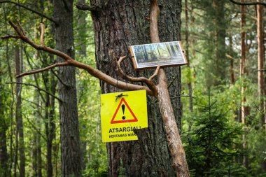 Visaginas, Lithuania - 08 16 2022: Two contradictive signs in forest, protecting sign and forest cutting sign on same wooden branch stand