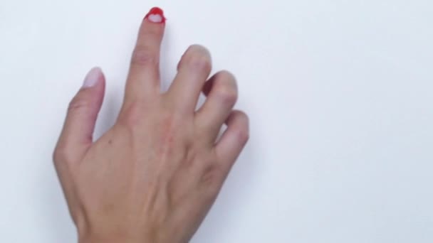 一个悲伤的小矮人被涂上红色的油漆，手指放在白色的背景上. — 图库视频影像