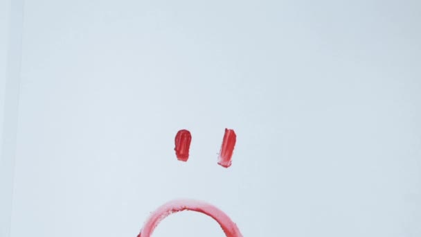 Triste sourire triste dessiné. peinture rouge sur un fond blanc est lavé avec un chiffon. — Video