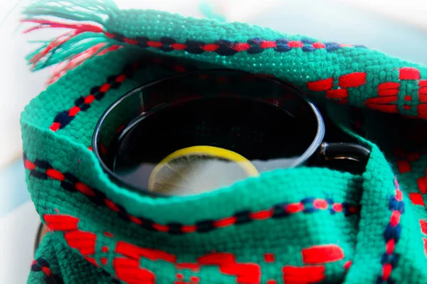 Yeşil ve kırmızı eşarba sarılmış limonlu bir fincan çay.. 