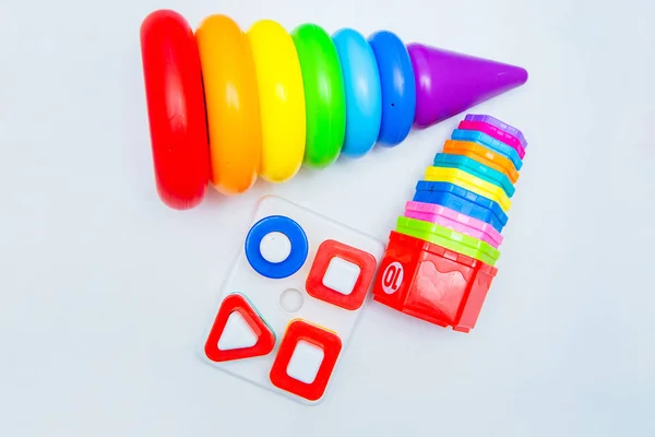 Childrens educational toys: a pyramid and sorters lie on a white background. top view, flat lay, copy space, isolate — Stock Photo, Image