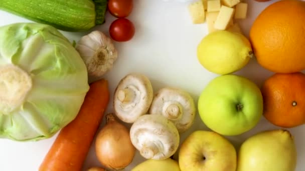 Frutas, legumes, cogumelos e produtos lácteos giram em círculo sobre um fundo branco. — Vídeo de Stock