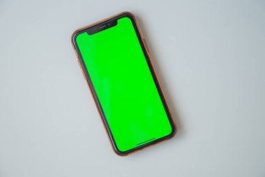 Yeşil ekranlı telefon beyaz arkaplanda..