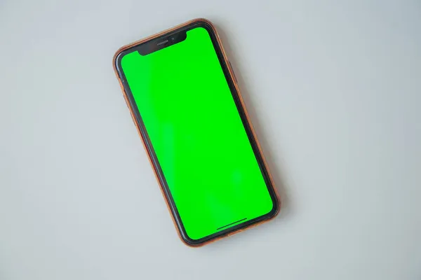 Yeşil ekranlı telefon beyaz arkaplanda..