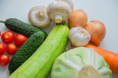 Sebzeler ve mantarlar beyaz arka planda yatar..