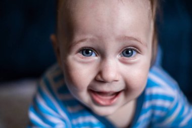 Çizgili bluz giymiş gülümseyen dişsiz bir çocuk gülüyor.. 