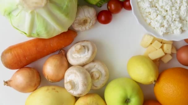 Frutas, legumes, cogumelos e produtos lácteos giram em círculo sobre um fundo branco. — Vídeo de Stock