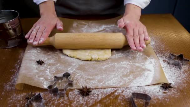 In the video, the dough layer is rolled out on parchment for baking with a rolling pin, then it is turned over, wiped with flour and rolled out again. — Stockvideo