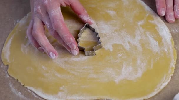 Na zwiniętym torcie w środku znajduje się wycinak do ciastek w postaci choinki, kucharz na nim naciska i ostrożnie go usuwa.. — Wideo stockowe
