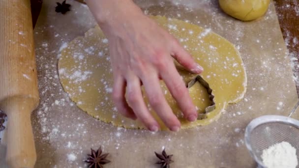 Na massa enrolada, o cozinheiro corta biscoitos em todo o texto com um cortador de biscoitos na forma de uma árvore de Natal.. — Vídeo de Stock
