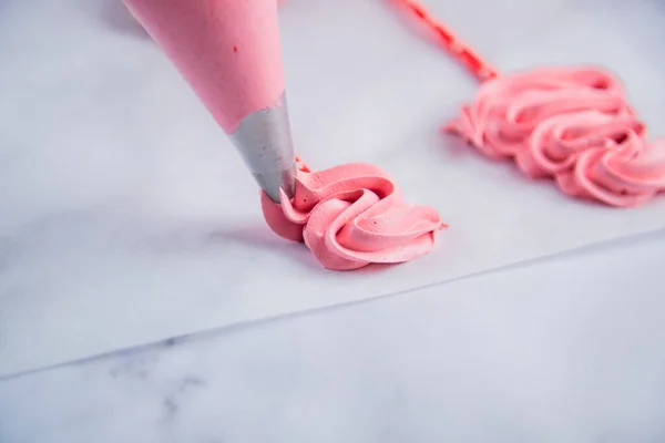 Hamur torbasından, pembe bir bizet, yılbaşı ağacı şeklinde bukleli bir kağıt üzerine serilir..