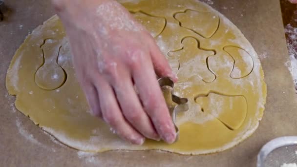 Su un pezzo di pasta arrotolata, che giace su pergamena, i biscotti vengono tagliati con figure diverse da intagliatori.. — Video Stock