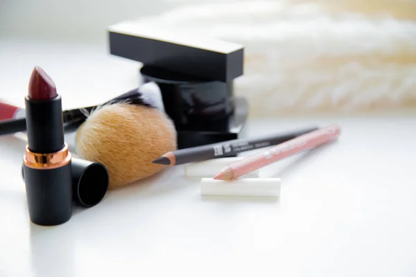 Dua pensil untuk mata dan bibir, lipstik, sikat, blush berbaring bersama di latar belakang putih — Stok Foto