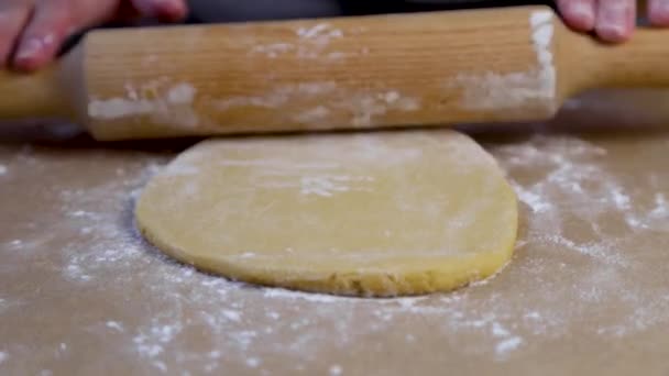 No vídeo, o chef de pastelaria rola a massa no pergaminho com um rolo, em seguida, desdobra o pergaminho e rola-lo para fora do outro lado. — Vídeo de Stock
