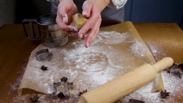Na filmie, cukiernik trzyma ciasto, posypuje mąką, a następnie umieszcza go na pergaminie i zaczyna poziomować go w kole. Film w ciemnym klawiszu — Wideo stockowe