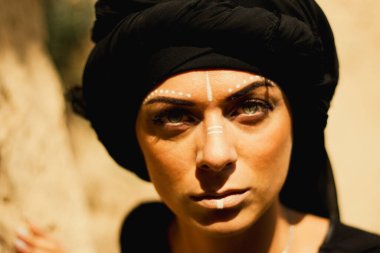 Makyajlı ve yüz sanatıyla kabile ya da Orta Doğu tarzında güzel bir kadının portresi..