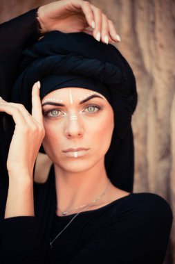 Makyajlı ve yüz sanatıyla kabile ya da Orta Doğu tarzında güzel bir kadının portresi..