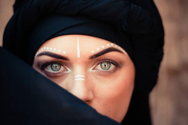 Portret van een jonge mooie vrouw met make-up en gezichtskunst in tribale of Midden-Oosterse stijl. — Stockfoto