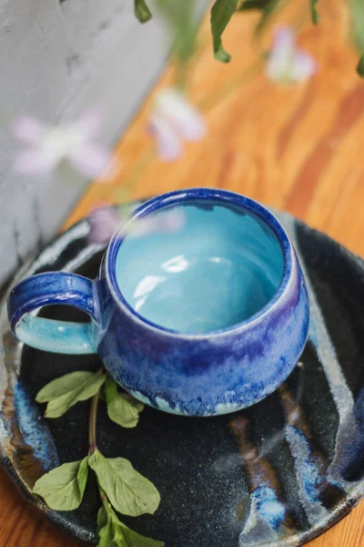 Seramik bardak koyu mavi, açık mavi ve nane renginde buruşmuş. Gri ve ahşap arka plan. Tasarımın için bir yer.
