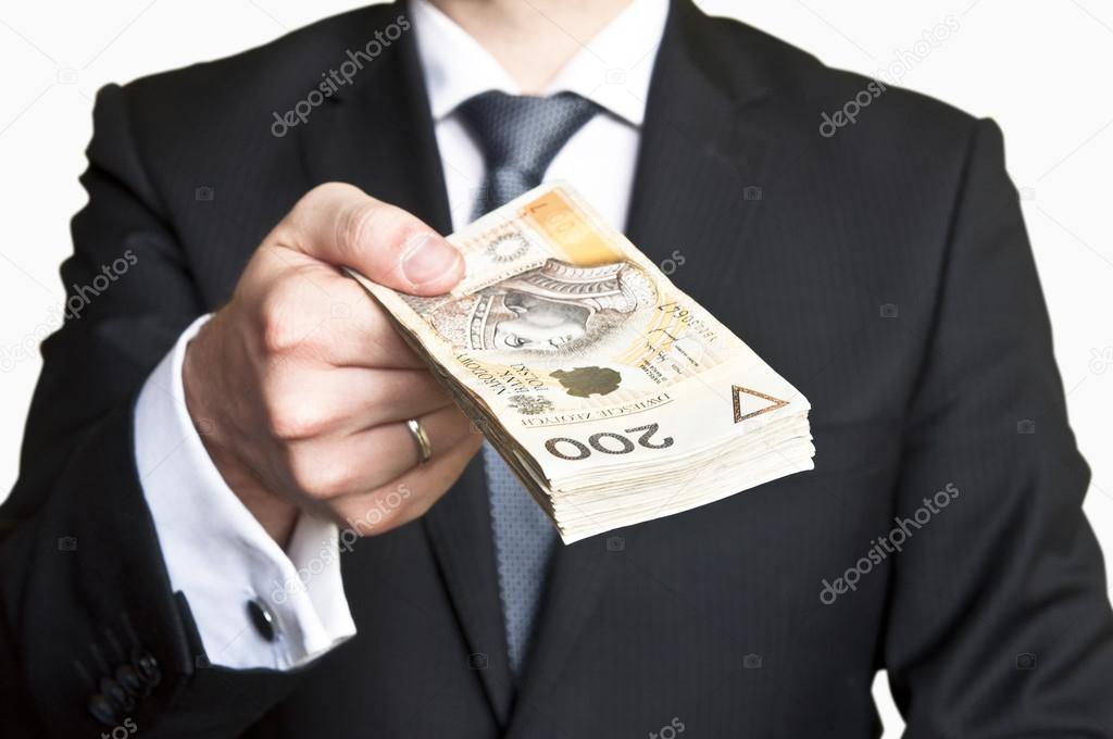 Businessman in suit and tie handing a lot of money