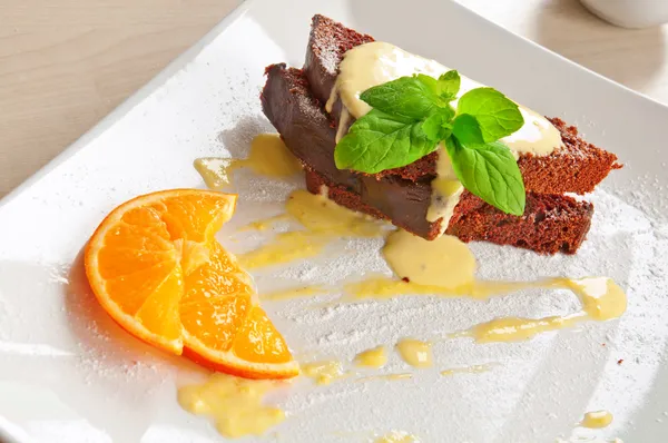 Chocolate brownie cake with vanilla sauce — Stock Photo, Image