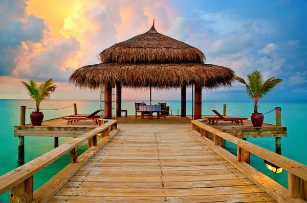 Tropische Hütte auf dem Wasser bei Sonnenuntergang — Stockfoto